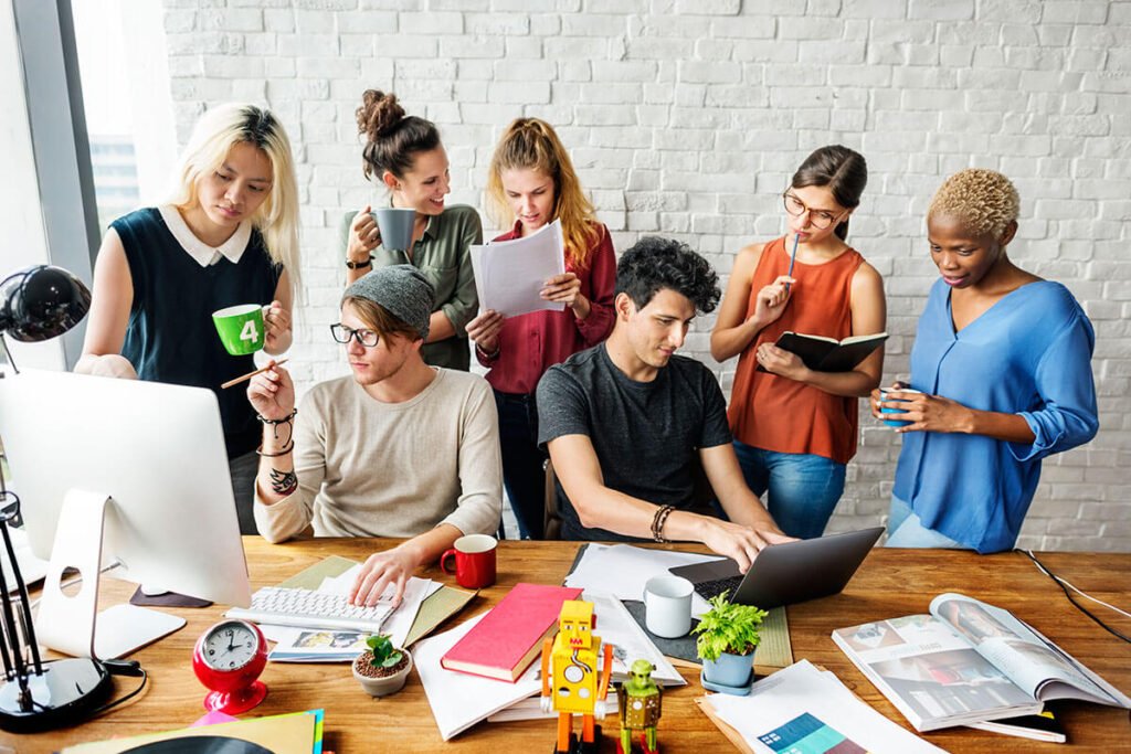 Creative team collaborating on digital marketing strategies around a workspace.